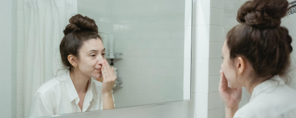 A woman washer her face with a cream.
